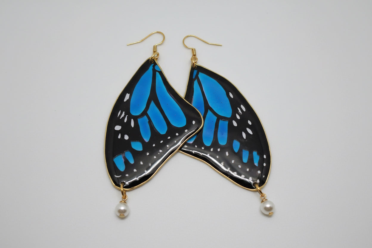 Blue butterfly wing earrings on a white background