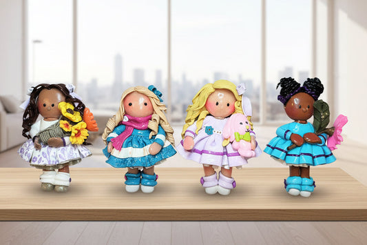 Four small dolls with different hairstyles and outfits on a white background